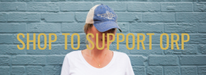 Woman wearing hat with SHOP TO SUPPORT text