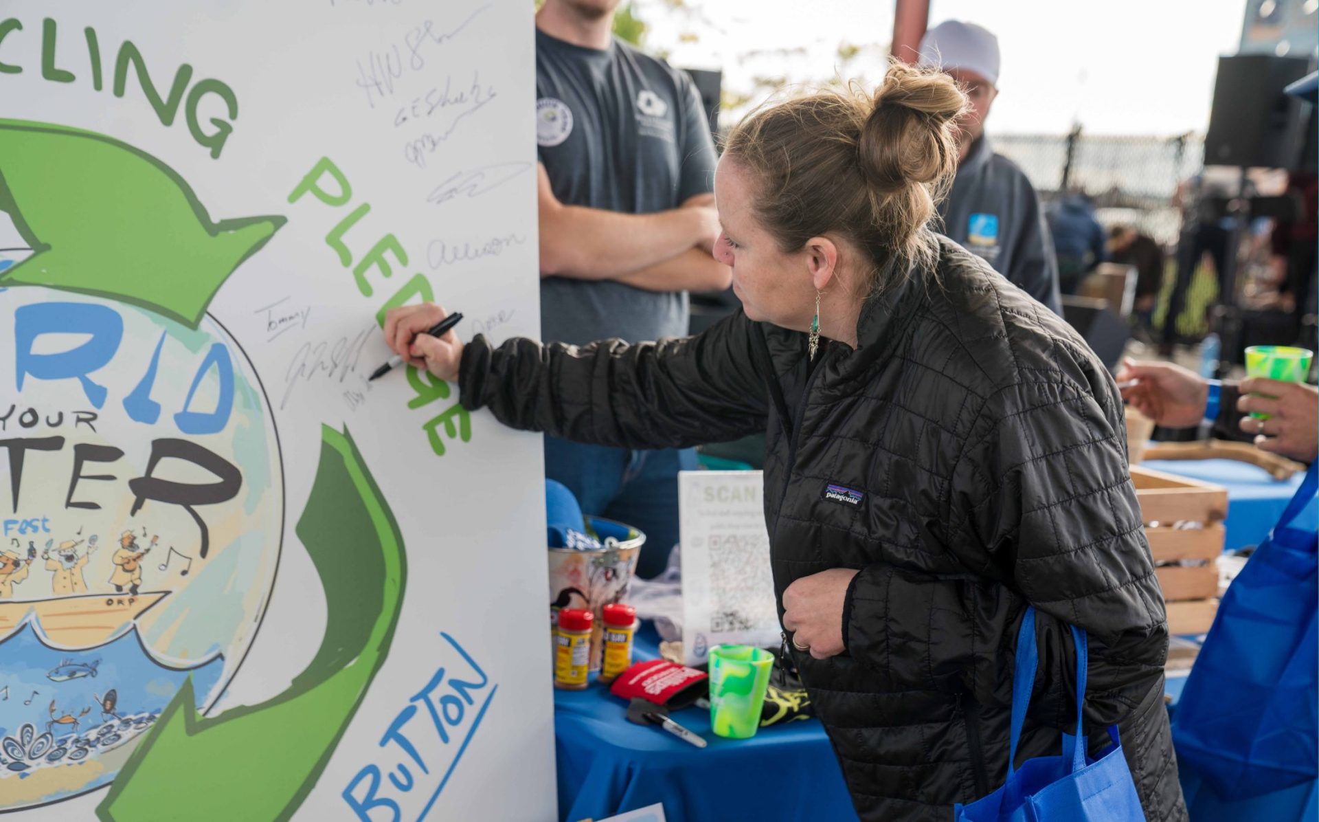 White woman signing shell recycling pledge