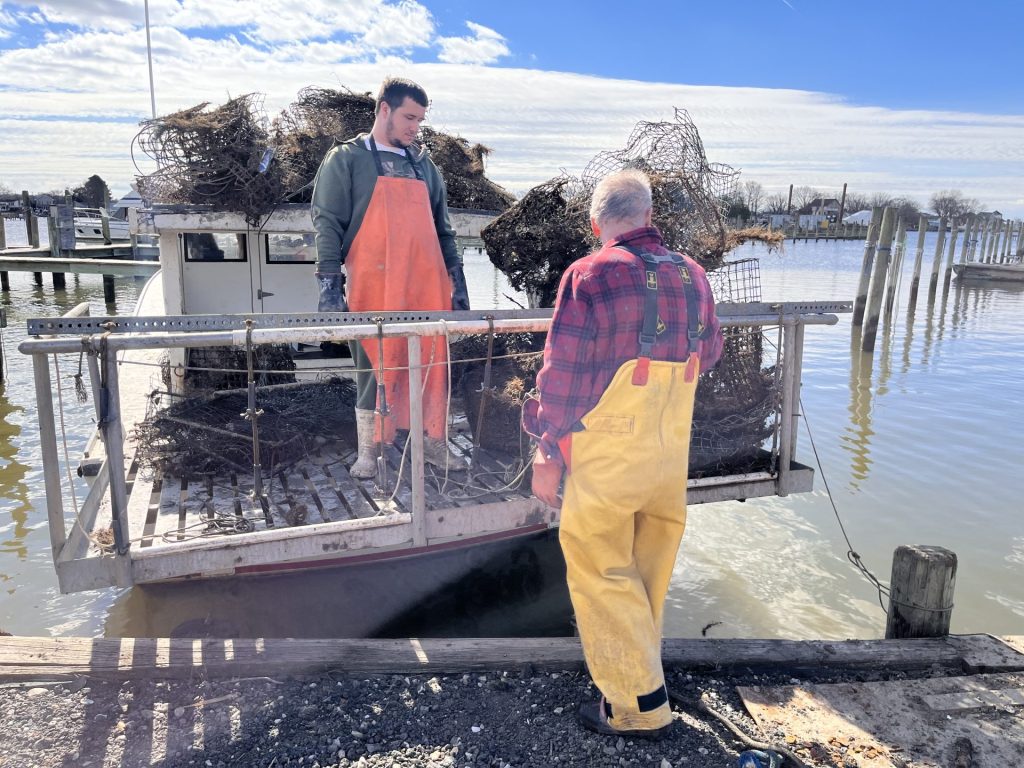 Watermen standing at back of boat